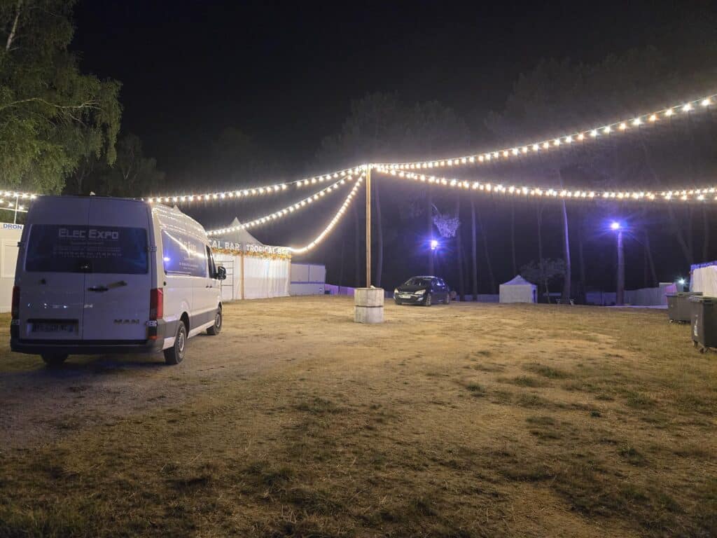 Guirlande guinguette Elec Expo installée de nuit sur un site événementiel en forêt
