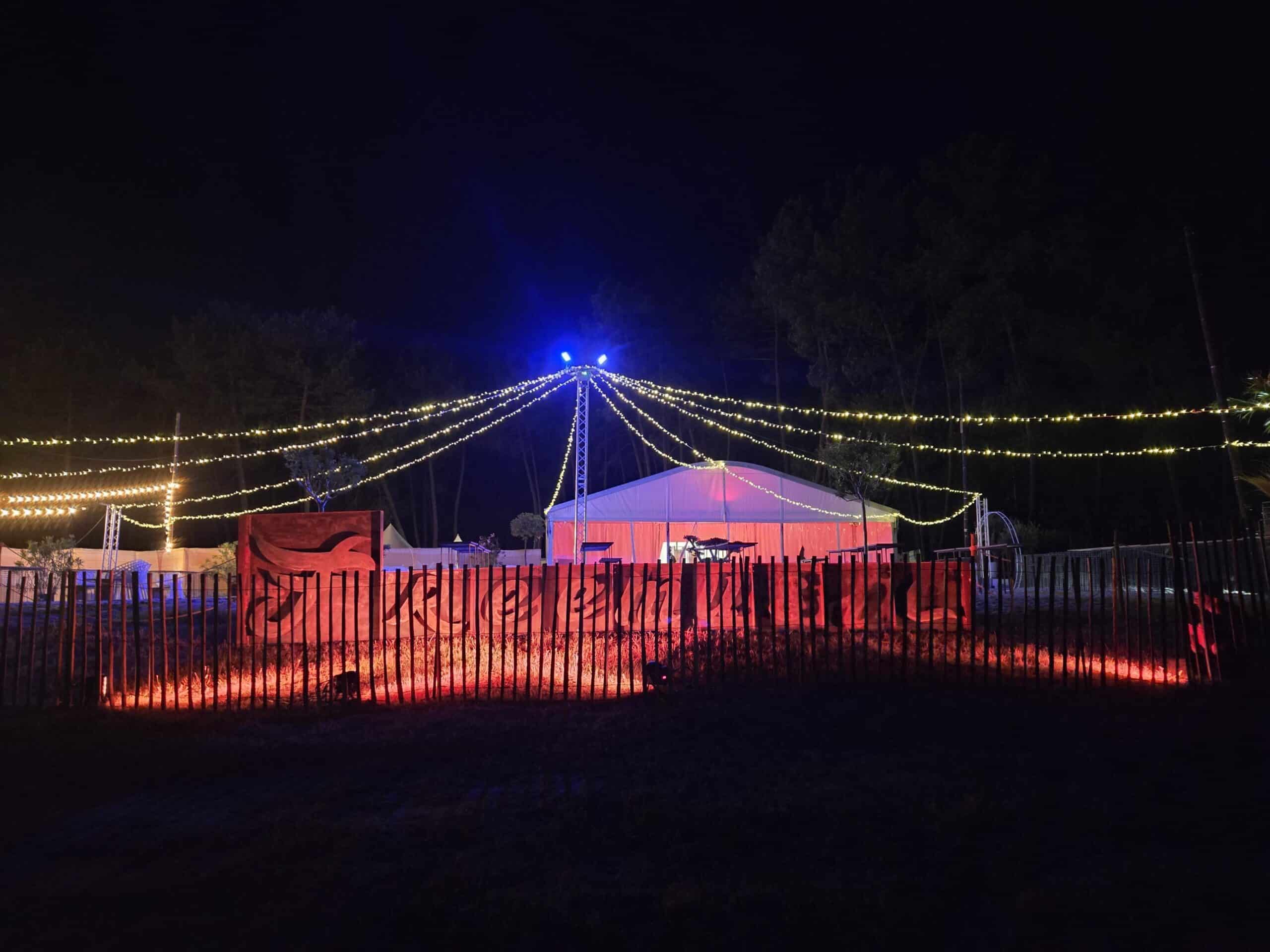 Structure de mât et guirlandes lumineuses éclairant un chapiteau évènementiel de nuit - Elec Expo