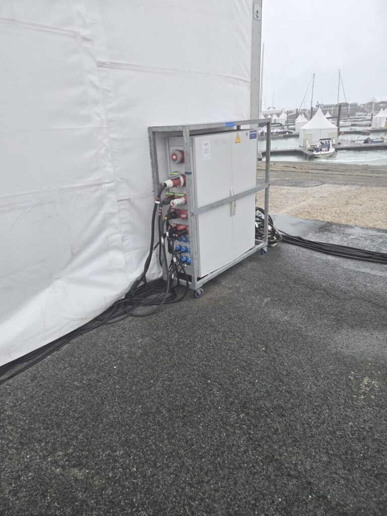 Armoire de distribution électrique temporaire installée à proximité d’une tente événementielle